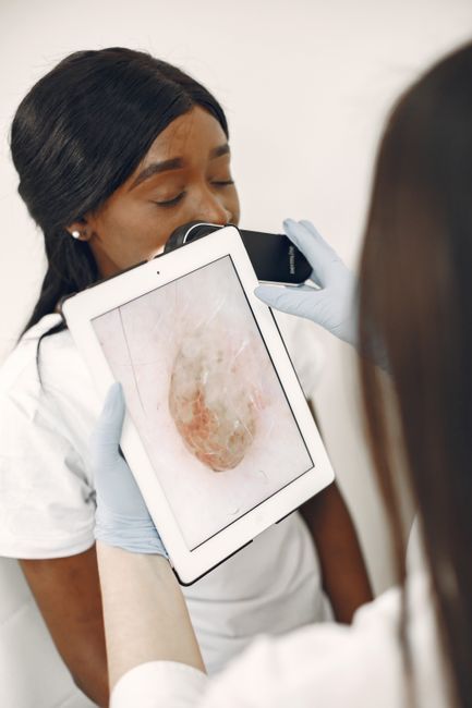A dermatologist uses advanced technology for a skin examination in a clinic setting.